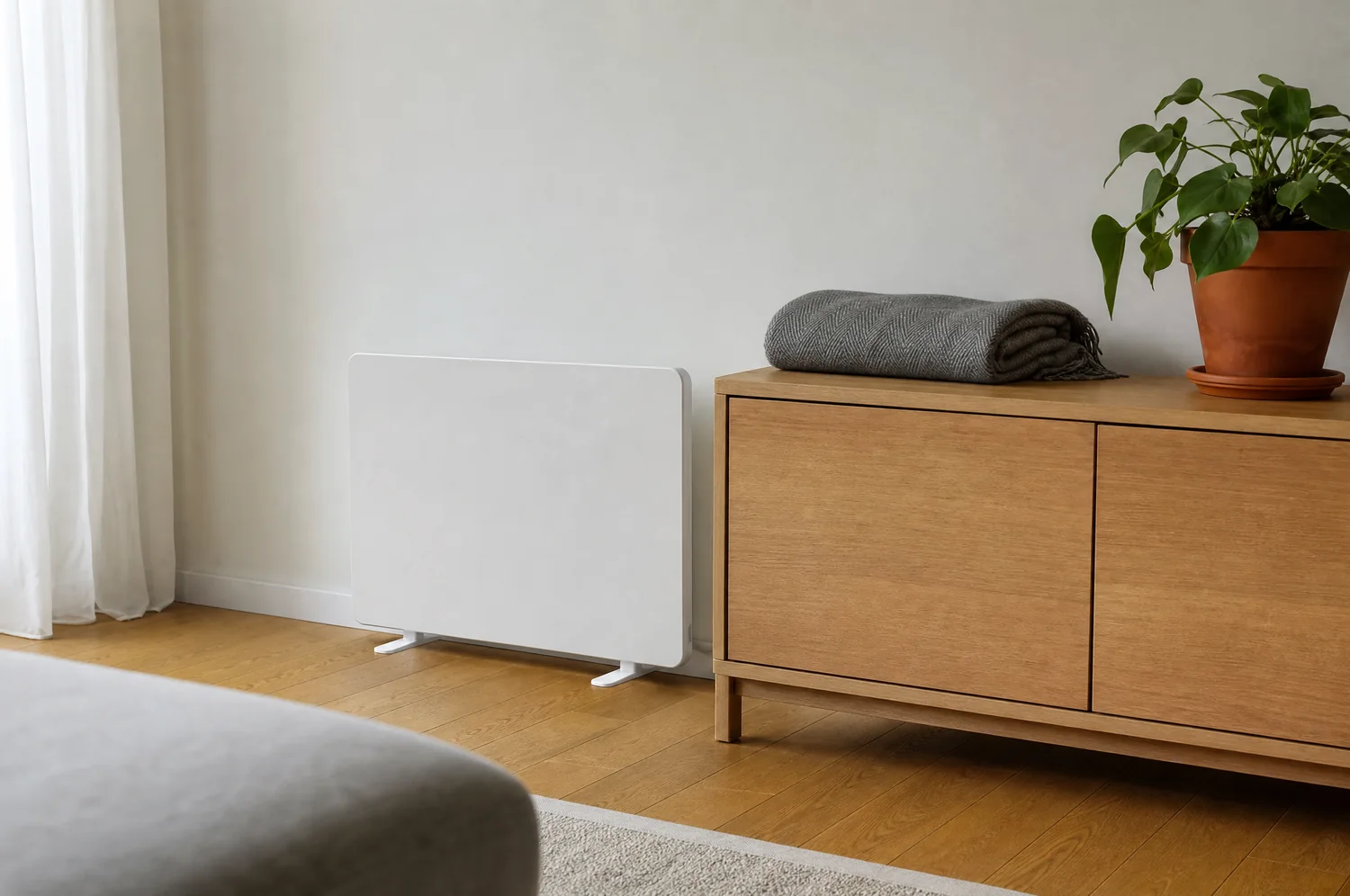 A living room with a panel heater beside a sideboard